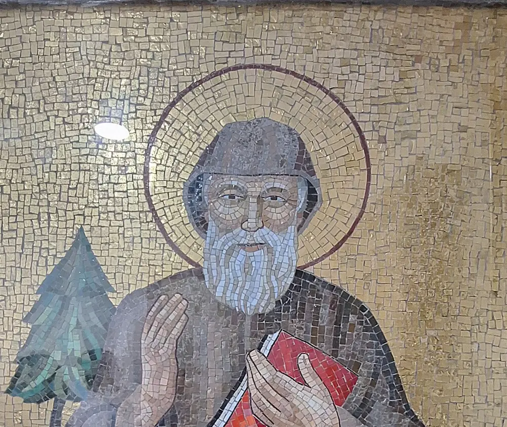 A mosaic portrait of Saint Charbel with a cedar of Lebanon, raising one hand in blessing