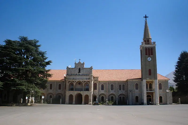 The Maronite Patriarch's summer residence at Dimane, a long stone building with a bell tower and a cedar tree in front