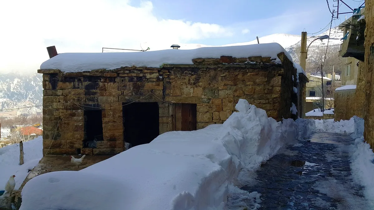 Schnee auf den alten Steinhäusern von Bekaa Kafra, mit dem Bergtal dahinter. Foto: LebanonUntravelled.com