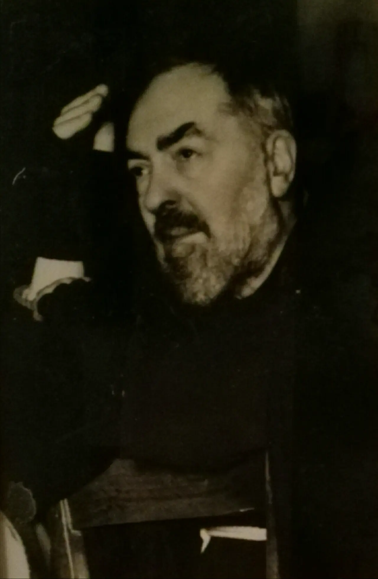 Padre Pio in his Capuchin habit, hands folded, showing the covering he wore over the wounds on his hands