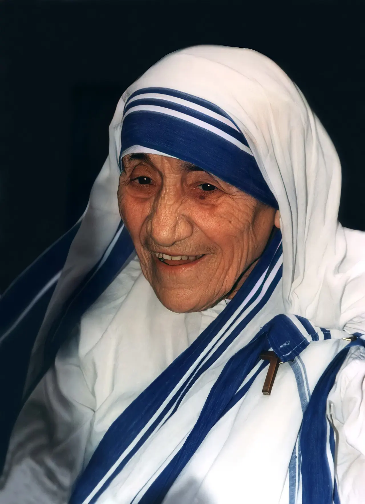 Mother Teresa in her white sari with blue border, hands folded