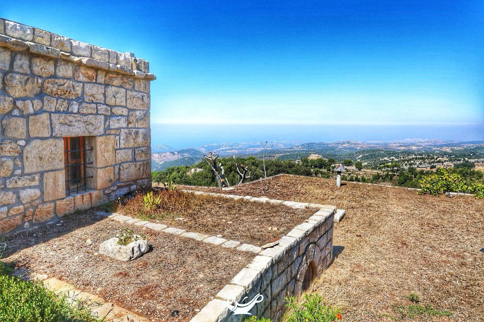 View toward the coast and the sea from the hermitage area of Annaya, over a stone terrace and flat roof
